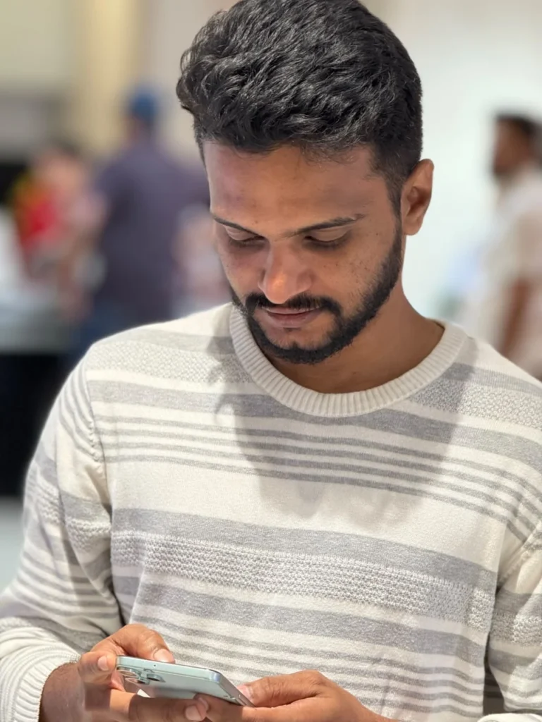 SEO specialist in Kerala working on a smartphone while reviewing SEO work